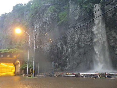 流木や土砂が横断管などをふさぎ、白糸の滝の水があふれた278号の現場(函館開建提供)